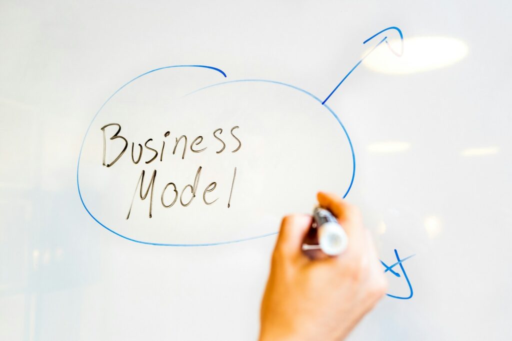 person writing creative business model on white paper